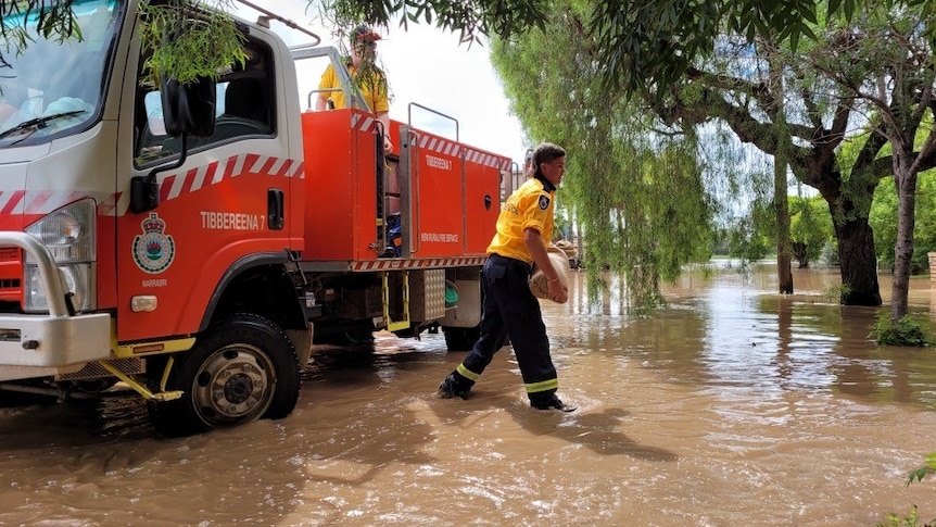 fire truck in floodwater with man walking