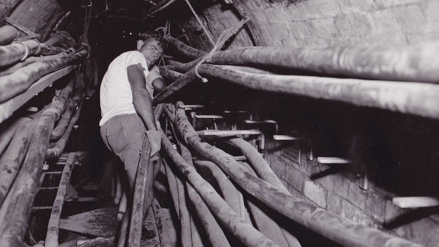 A man works on installing the coaxial cable