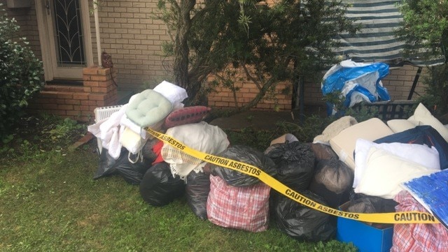 Bags of household items waiting to be removed after being tainted by asbestos dust.