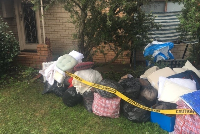 Bags of household items waiting to be removed after being tainted by asbestos dust.