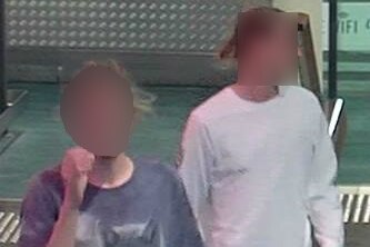 Two men walking through shopping centre, faces blurred