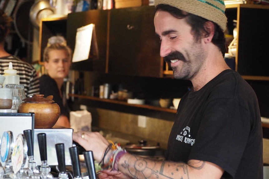 A man at the counter of a cafe.