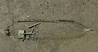 An aerial shot of the outline and remnants of a boat in the seabed.
