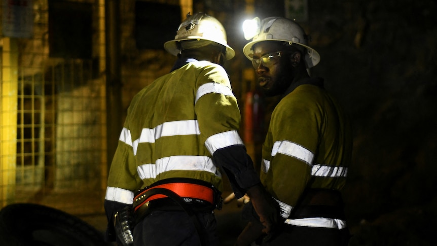 two men in an underground mine with low lighting