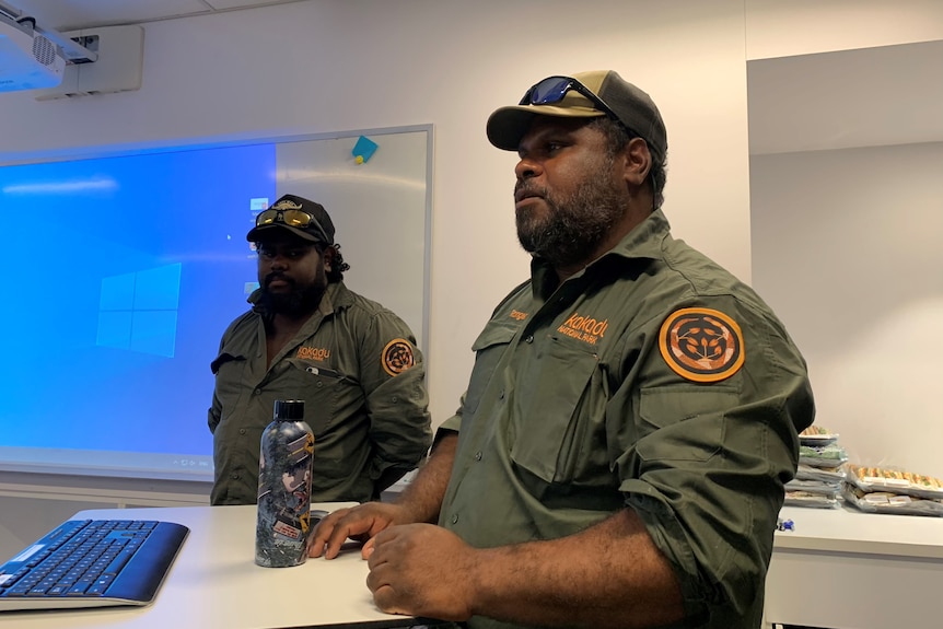 Dwayne wears a Kakadu National Park uniform and stands in an office 
