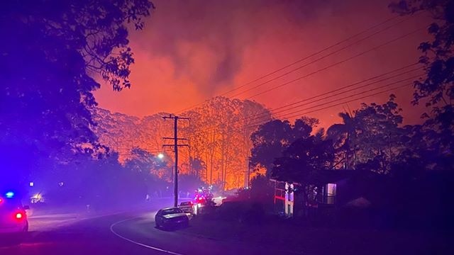 Fire burning close to properties at night in Lower Beechmont on Queensland's Gold Coast hinterland.