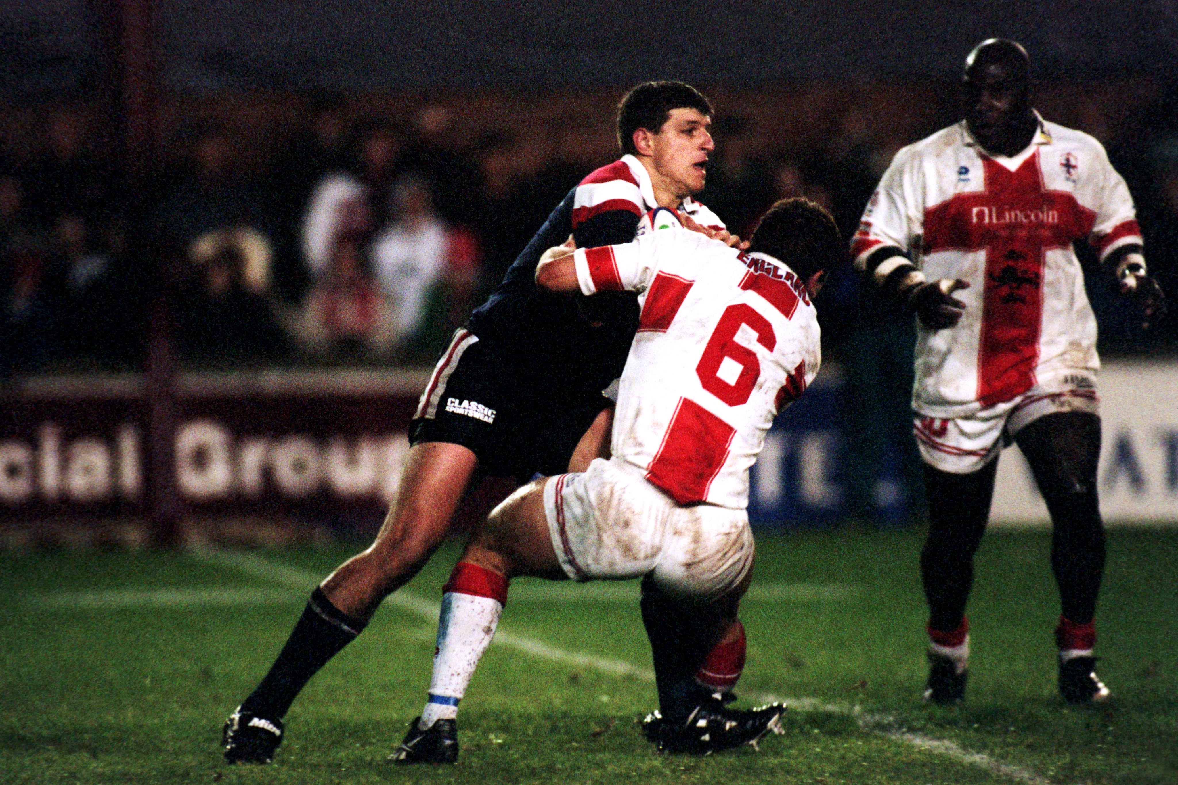 A man makes a tackle in a rugby league match