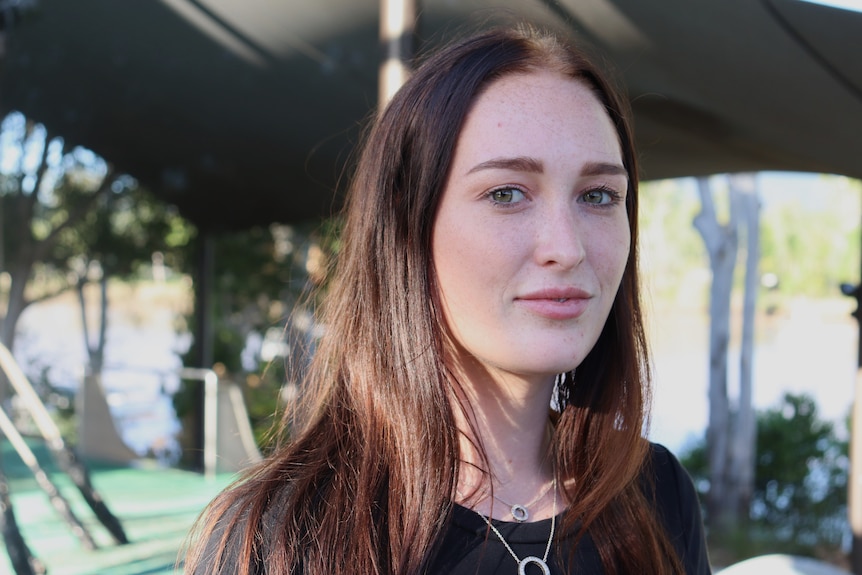 Woman looks at camera with neutral expression