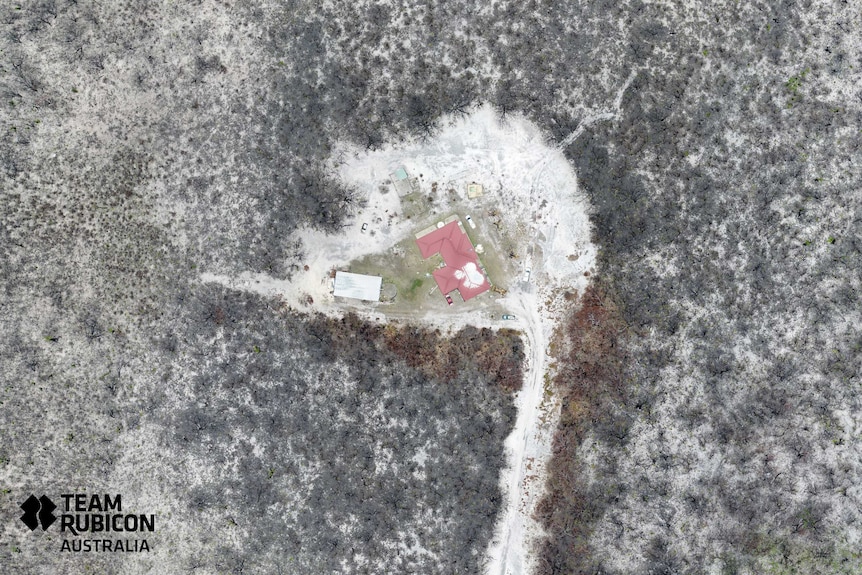 Aerial photo of house surrounded by burnt bushland.