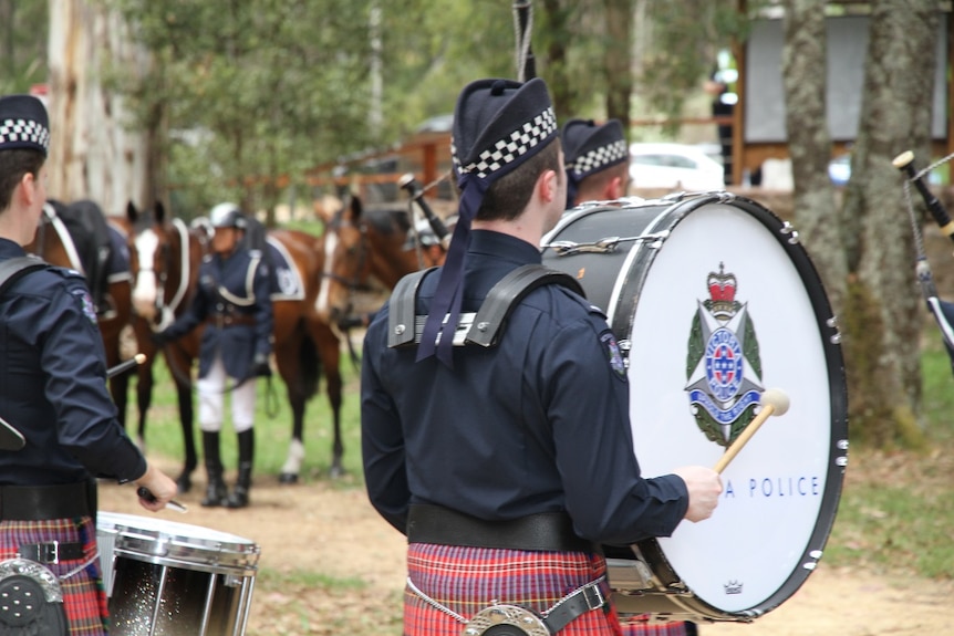 Policeman playing drums marching into the Stringybark Creek memorial site in Victoria