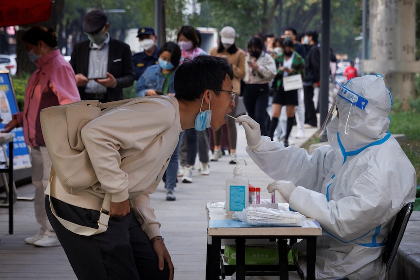 Un hombre se hace una prueba PCR COVID en Beijing, China