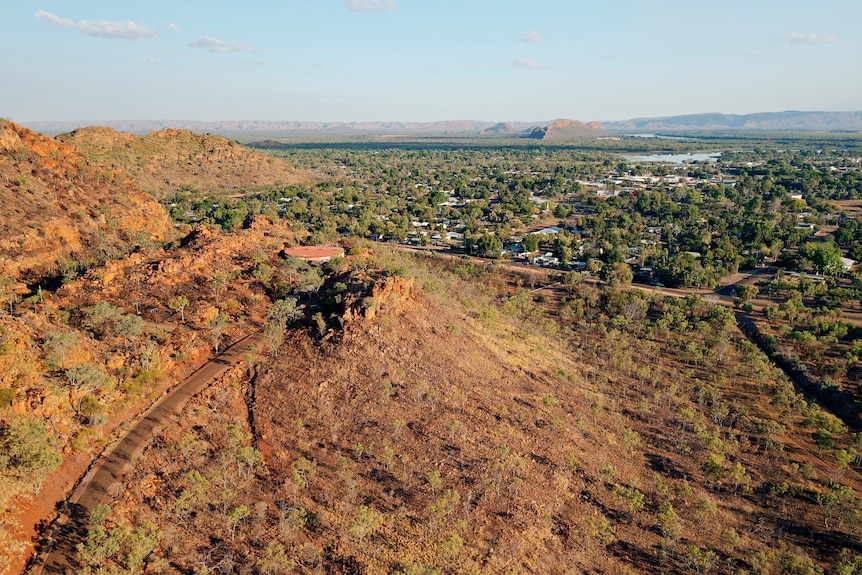 a drone shot of a town nestled between red rock ranges 