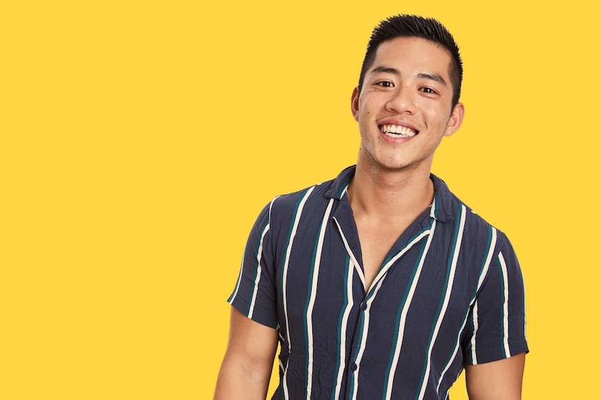 Photo of David Wang on a yellow background. He's faced racism on gay dating apps like Grindr.