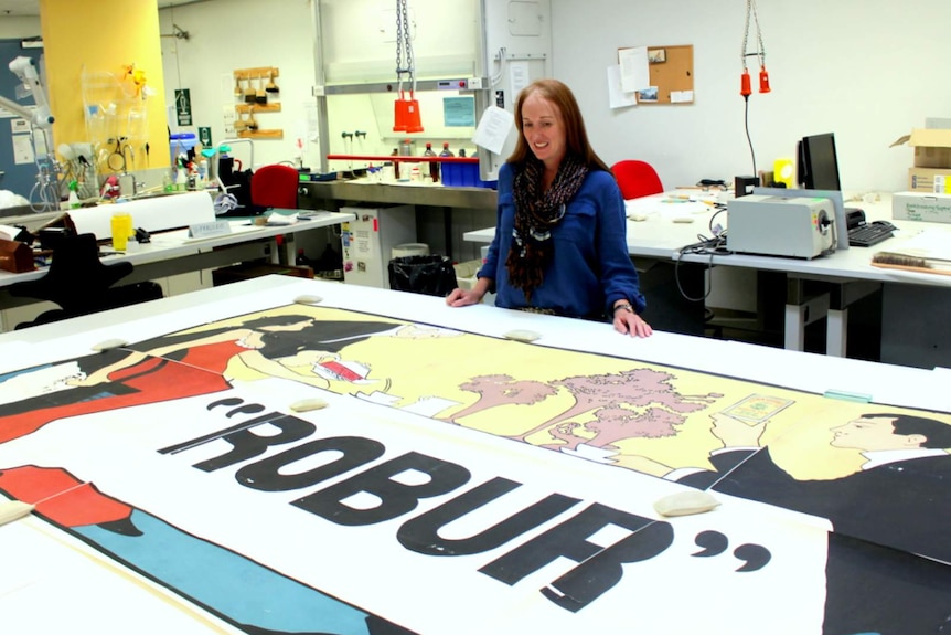 Conservator Caroline Milne with the restored poster.