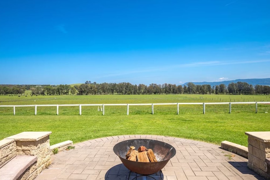 Whispering Pines firepit with paved area and seating with views to lush green grass