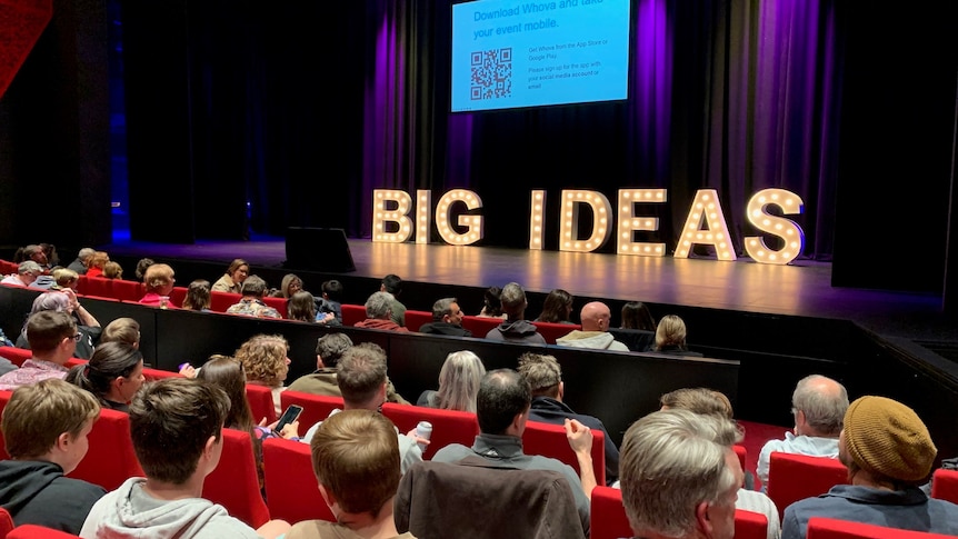 crowd sits in front of stage lit up with giant Big Ideas lettering