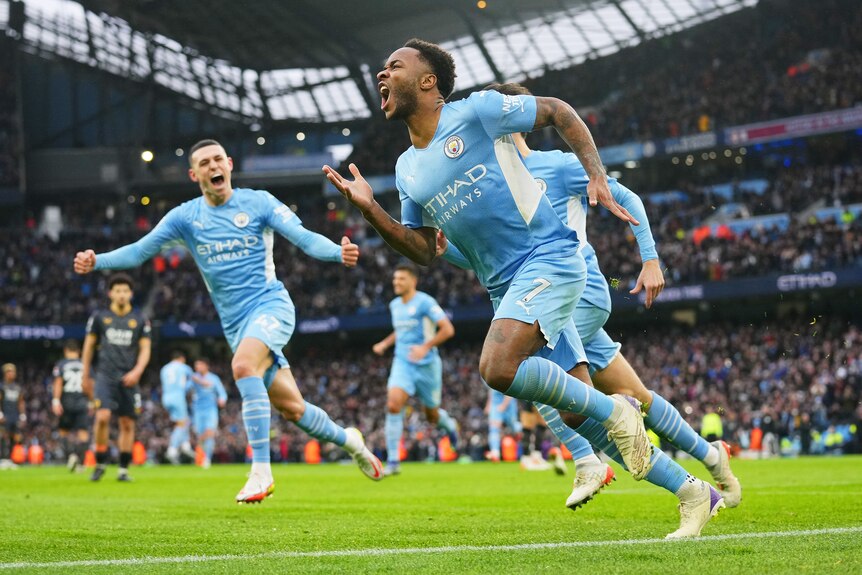 A Premier League footballer runs away shouting in celebration as his teammates race after him.