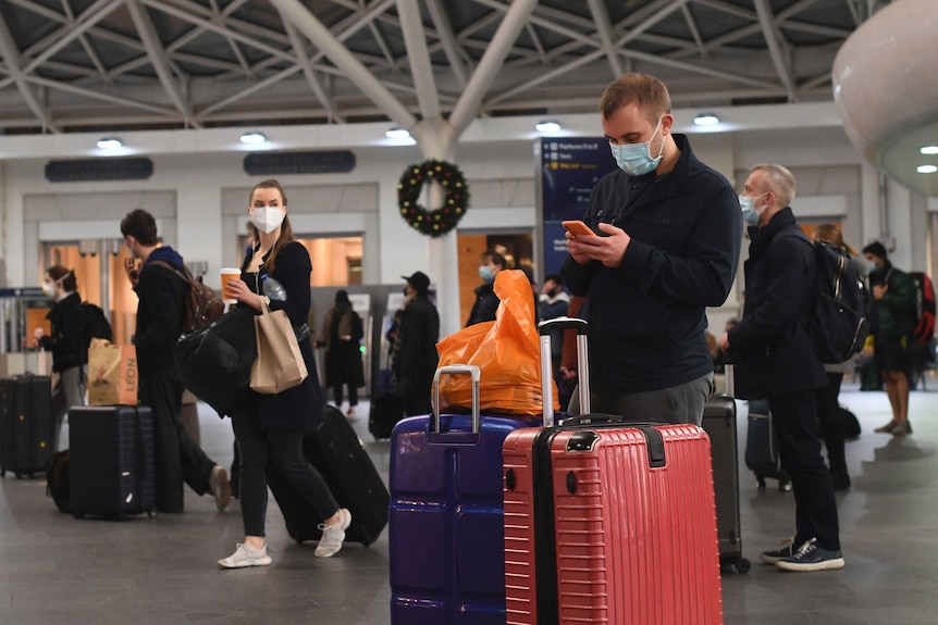 Travellers wait for trains on the concourse at King's Cross station in central London