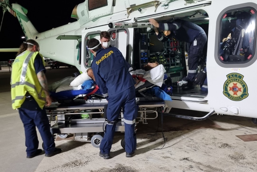 An injured man is loaded onto a helicopter 