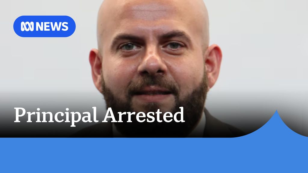 Principal Arrested: A man with no hair and a brown beard.