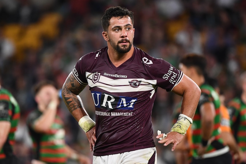 A Manly NRL player looks to his right as he leaves the field.