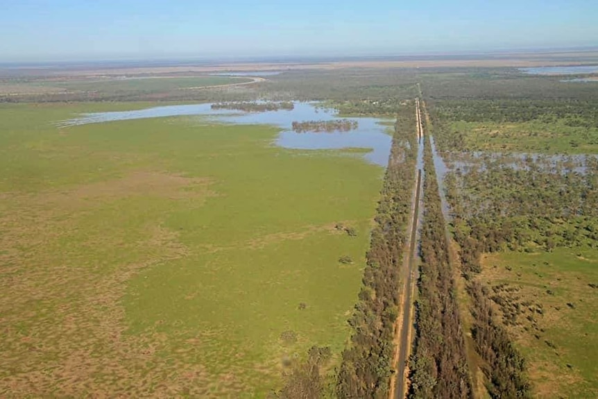 An aerial view of flooded outback road and paddocks