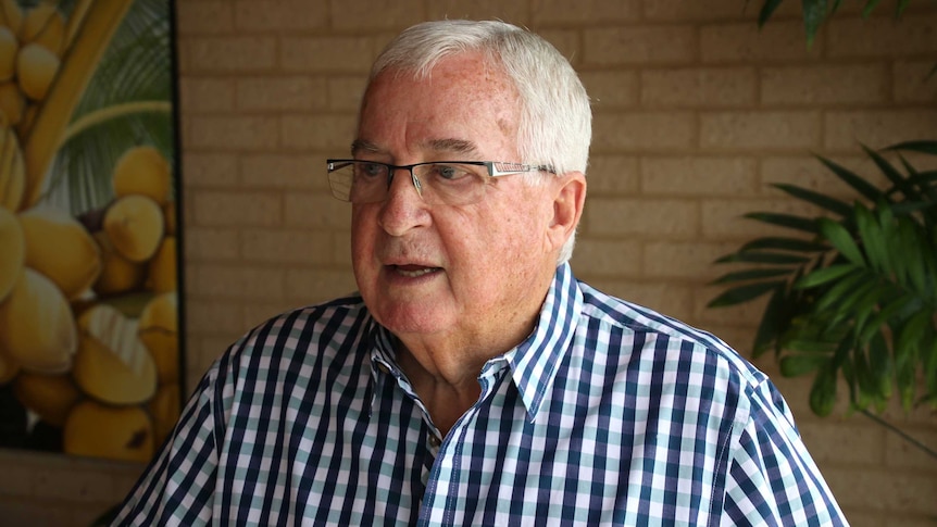 Mr Bowker speaks looking off to the right. He wears glasses and a checked shirt, standing in front of a wall.