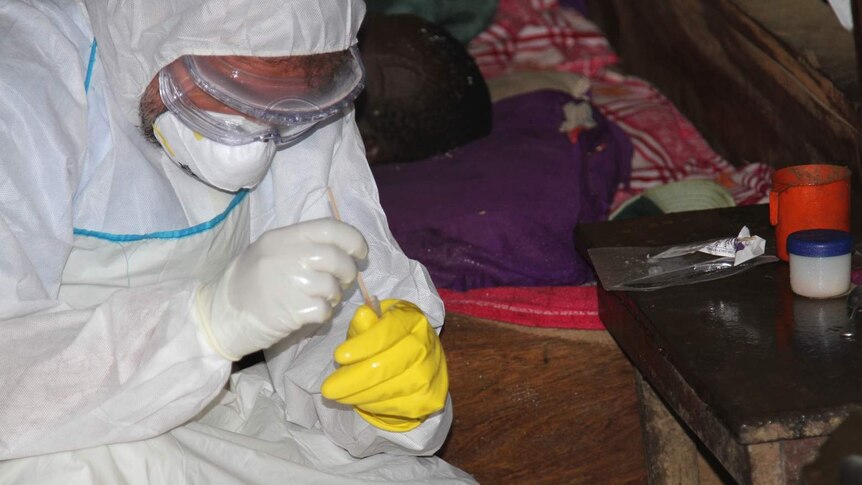 Aid worker providing treatment to an Ebola patient