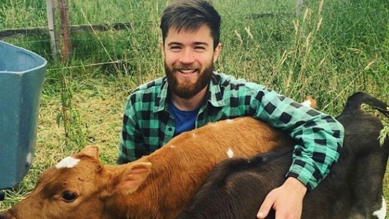 Danny Kinnear with his two calves Angus and Julie at his farm in Daylesford, Victoria