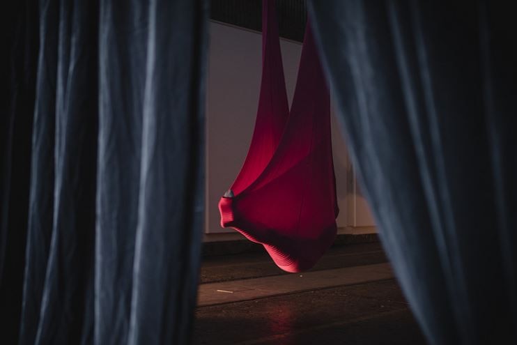 A person suspended in a red cloth in an art installation called 'Hypnopod'