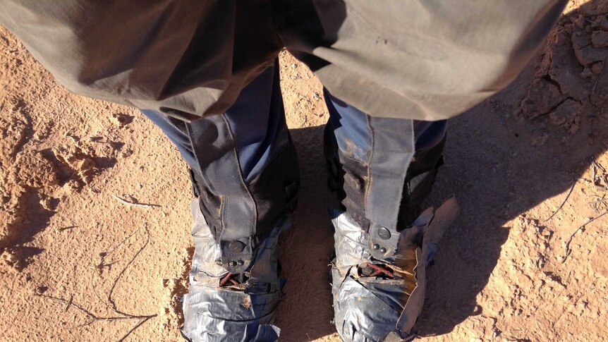 A man's boots wrapped in gaffer tape.