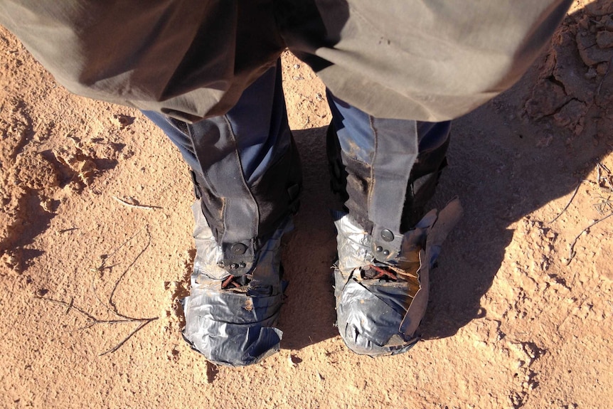 A man's boots wrapped in gaffer tape.