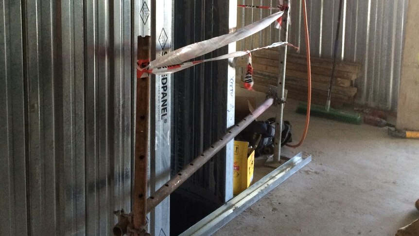 A ventilation shaft at an East Perth apartment site guarded by tape and a metal bar.