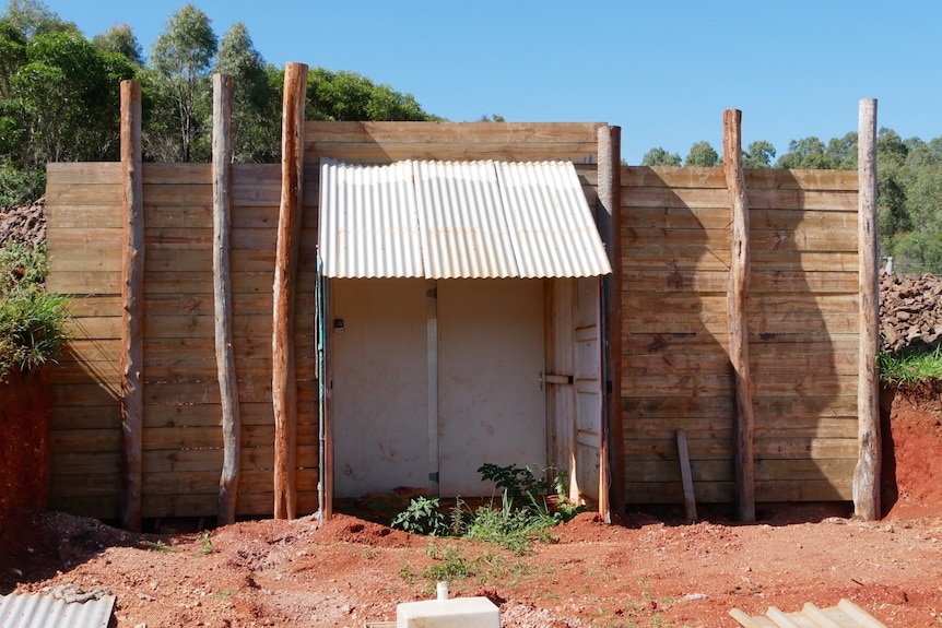 A shipping container built into outdoor wall with wood either side