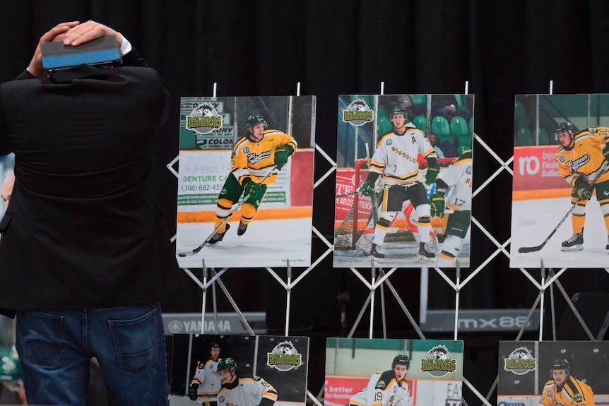 A man is seen looking at displayed photos of the team members while holding his head in distress.