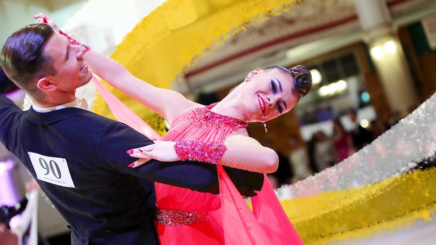A male and female couple in ballroom attire dancing on the dance floor.