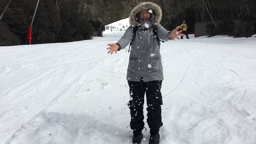 Seorang perempuan sedang berdiri dan bermain salju
