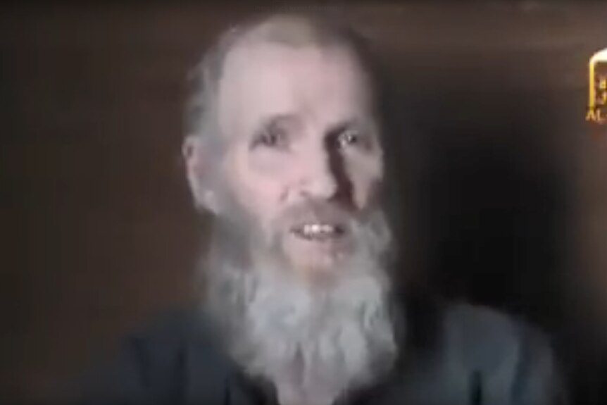 A video still shows a with grey hair speaking to the camera.