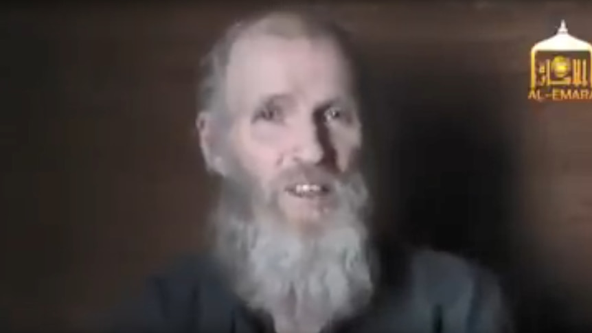 A video still shows a with grey hair speaking to the camera.