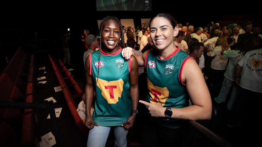 Priscilla Odwogo and Rachael Duffy showing off the foundation jumper or guernsey design at launch of the Tasmania Football Club.