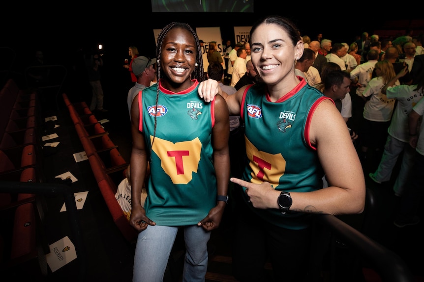 Priscilla Odwogo and Rachael Duffy showing off the foundation jumper or guernsey design at launch of the Tasmania Football Club.
