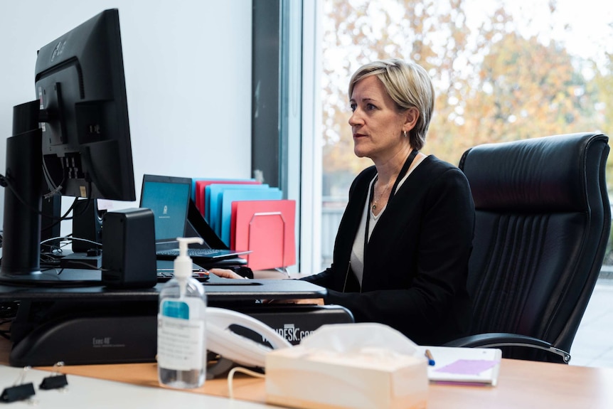 Field coordinator for the Public Health Emergency Operations Centre (PHEOC) Dr Clare Huppatz sits at a desk.