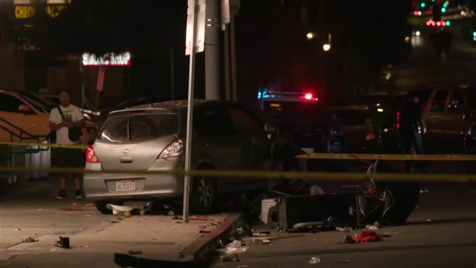  A silver car with a broken tail light crashed into a pole at night.