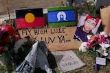 Flowers, flags and signs on the grass.