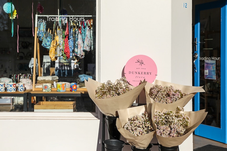 Large bunches of Geraldton Wax outside a shop front.