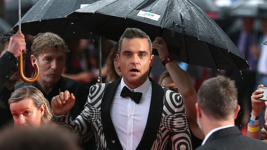 Robbie Williams poses for photos