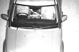 A traffic camera photo of a driver using the passenger seat belt lock