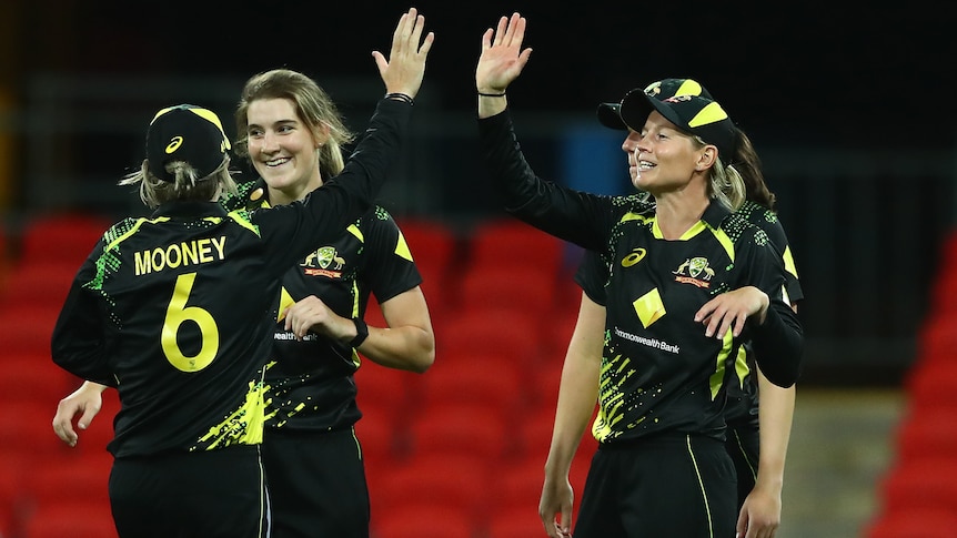 Four Australian players celebrate during the win over India in the third women's T20 international.