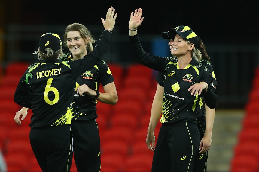 Four Australian players celebrate during the win over India in the third women's T20 international.