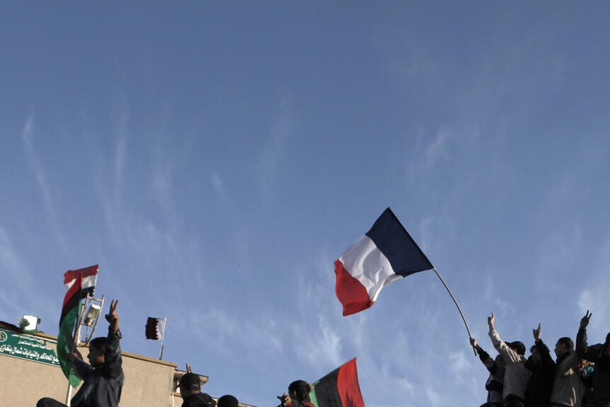 Libyans wave the French flag atop a Gaddafi tank